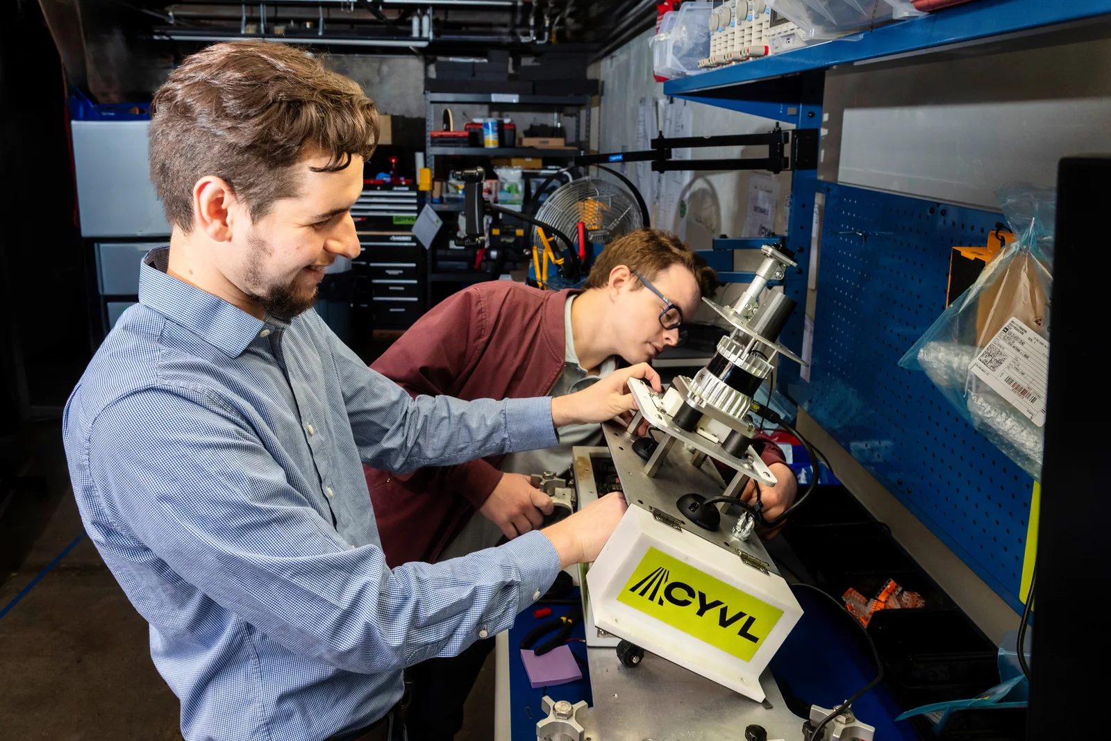 Two CYVL engineers building a sensor rig together in the lab